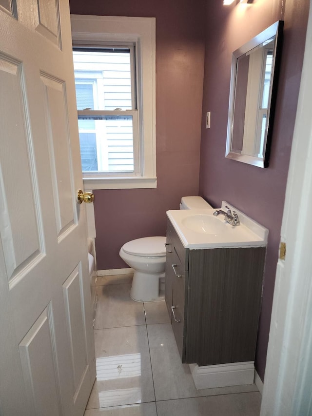 bathroom featuring tile patterned flooring, toilet, vanity, and baseboards