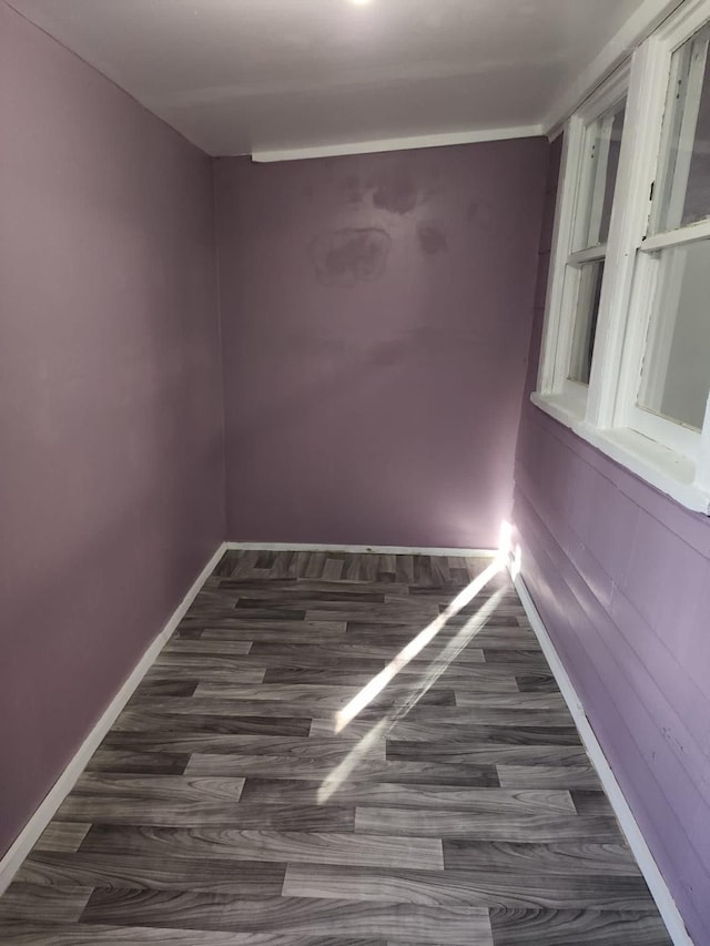 empty room featuring dark wood-style floors and baseboards