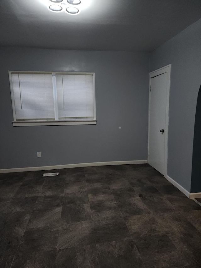 empty room with baseboards and visible vents