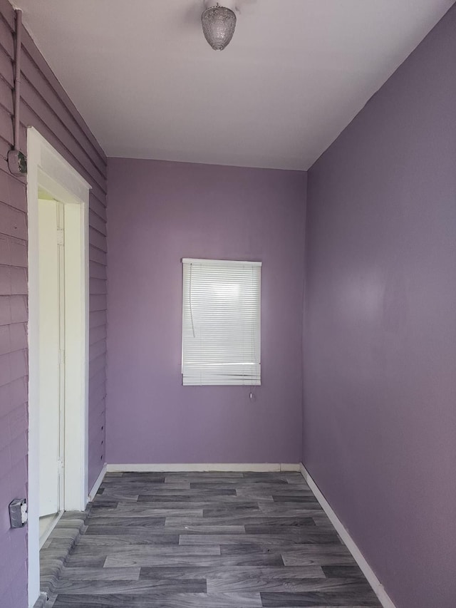 empty room with baseboards and wood finished floors