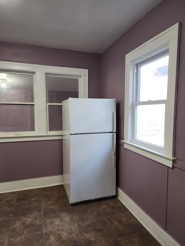 kitchen featuring freestanding refrigerator and baseboards