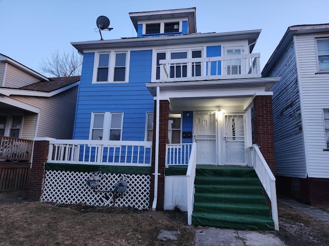 american foursquare style home featuring a balcony and covered porch