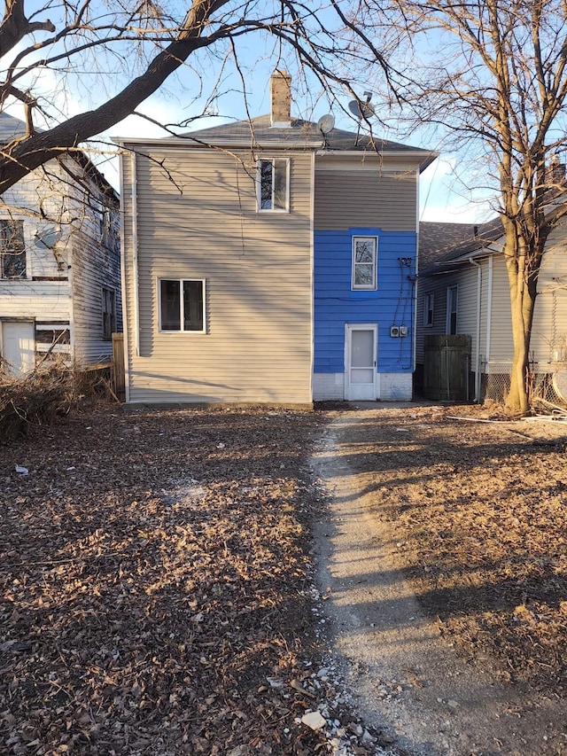 back of property with a chimney