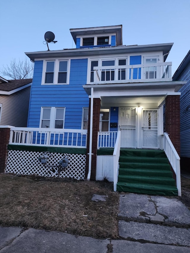 traditional style home featuring a balcony and a porch