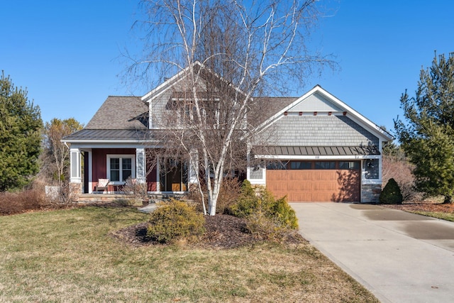 craftsman inspired home featuring a front lawn, concrete driveway, metal roof, a garage, and a standing seam roof