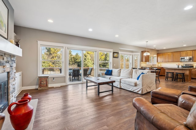 living area with dark wood finished floors, recessed lighting, a fireplace, and baseboards