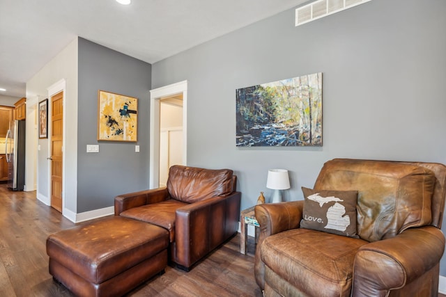 living area with dark wood finished floors, visible vents, recessed lighting, and baseboards