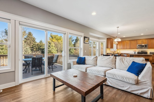 living room with recessed lighting, baseboards, and light wood-style floors