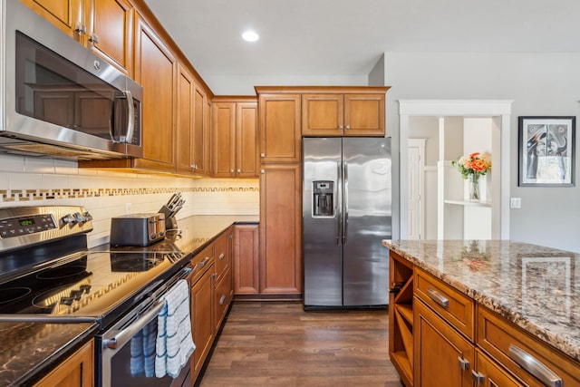 kitchen featuring brown cabinetry, dark wood-style flooring, backsplash, and stainless steel appliances