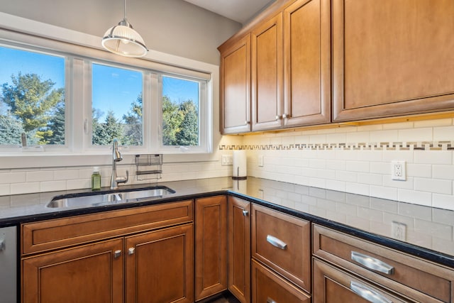 kitchen with brown cabinets, decorative light fixtures, tasteful backsplash, and a sink