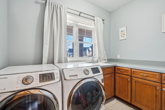 clothes washing area featuring a sink, washing machine and dryer, and light tile patterned floors