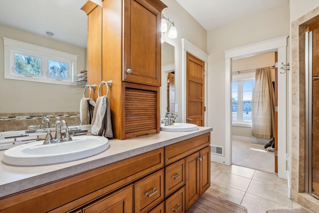 bathroom with a sink, a healthy amount of sunlight, and tile patterned floors