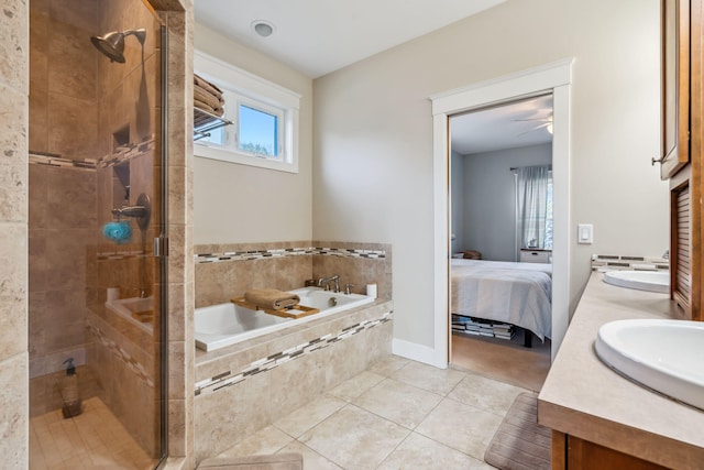 full bathroom with double vanity, a sink, tile patterned flooring, a shower stall, and a garden tub