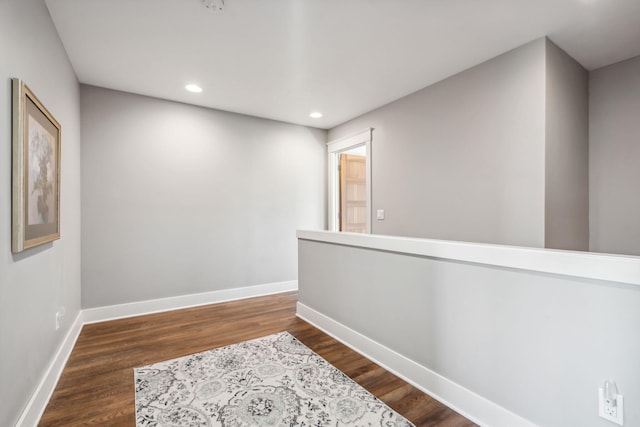 hallway with recessed lighting, wood finished floors, and baseboards