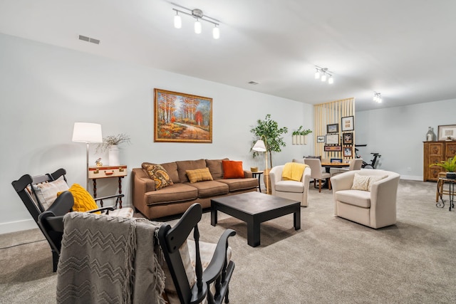 living area with light carpet, visible vents, rail lighting, and baseboards