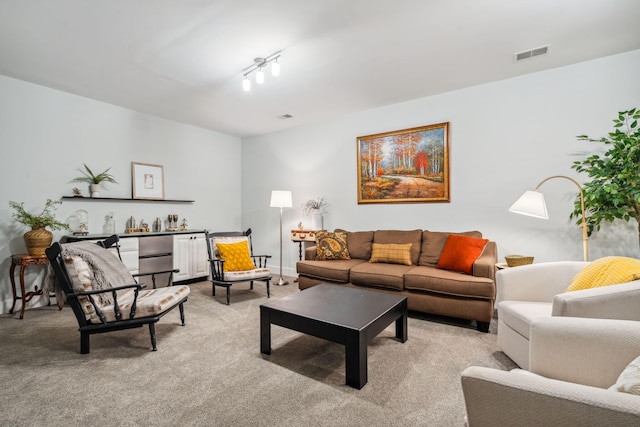 living area with visible vents and light carpet