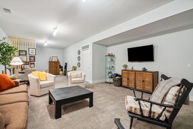 living room with visible vents, light carpet, and baseboards