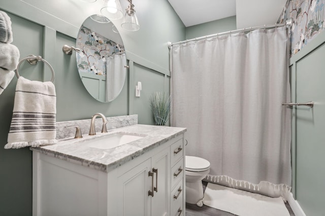 bathroom featuring a shower with shower curtain, toilet, and vanity