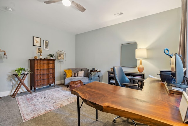 carpeted office with visible vents, baseboards, and a ceiling fan