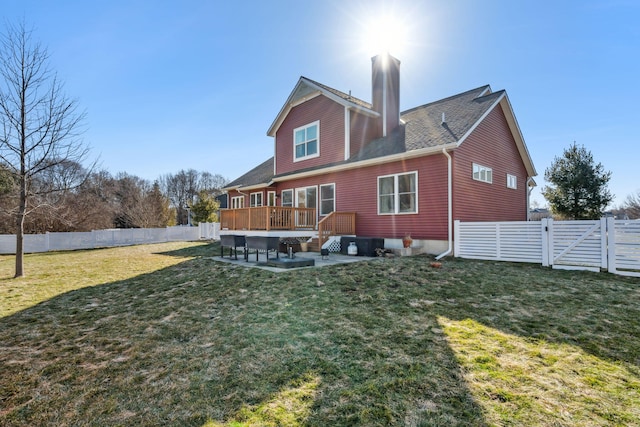 back of property with a yard, a fenced backyard, a chimney, and a patio area