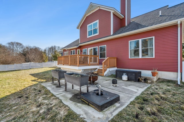 back of house featuring a fire pit, fence, a wooden deck, a chimney, and a patio area