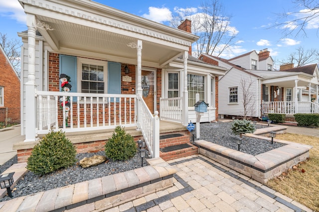 neoclassical / greek revival house with a porch and brick siding