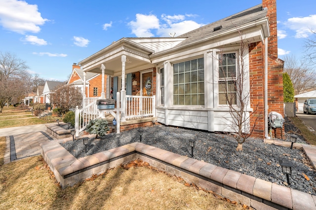 view of front of house featuring brick siding and a porch