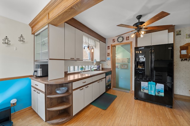 kitchen featuring a sink, open shelves, freestanding refrigerator, white cabinets, and wallpapered walls