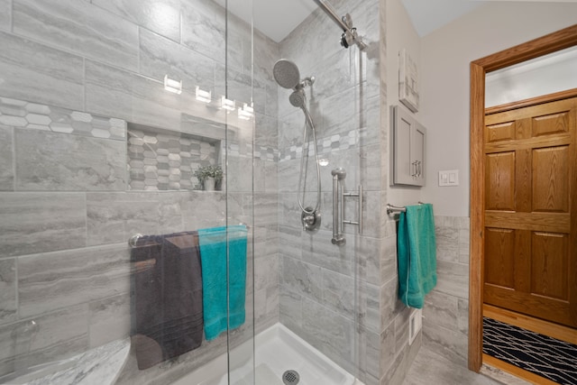 bathroom featuring a shower stall and tile walls