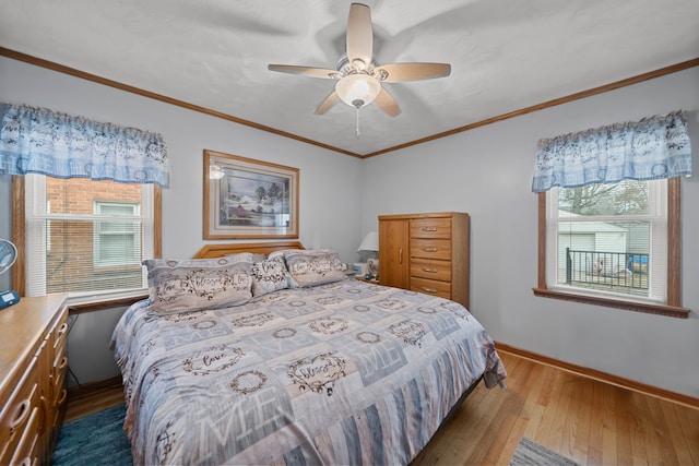 bedroom with ornamental molding, a ceiling fan, baseboards, and hardwood / wood-style floors