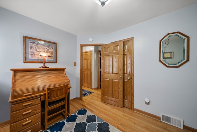 office area with visible vents, baseboards, and light wood-style flooring