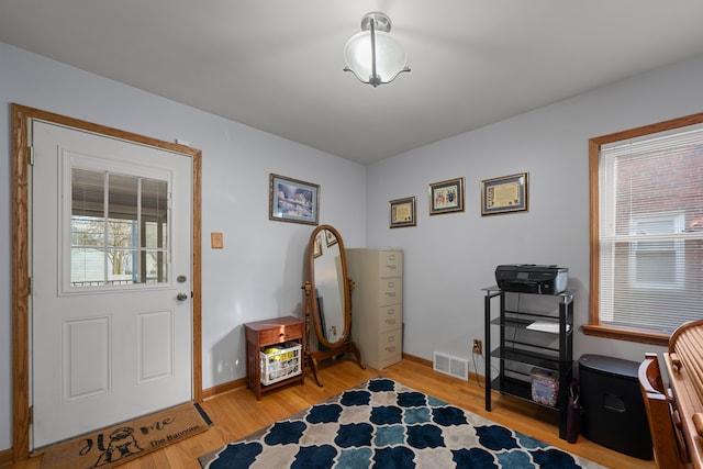 interior space with baseboards, visible vents, and light wood finished floors