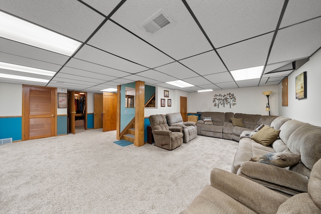 living room featuring a paneled ceiling, visible vents, carpet floors, and stairway