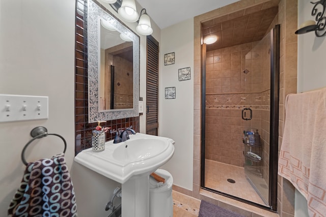 bathroom with toilet, a stall shower, and a sink