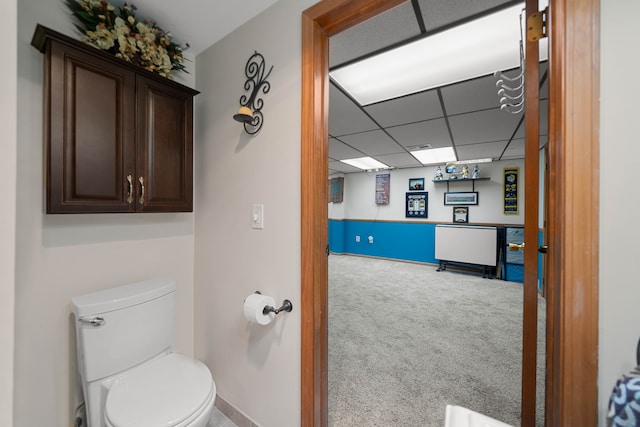 bathroom with a drop ceiling, baseboards, and toilet