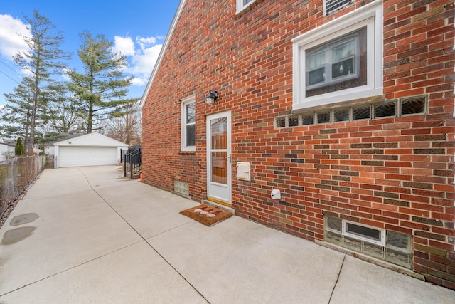 exterior space with a detached garage, brick siding, and an outdoor structure