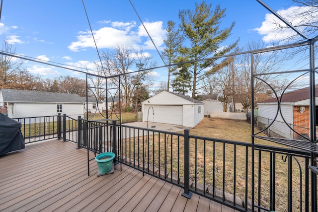 wooden deck featuring an outdoor structure, area for grilling, a lawn, and a detached garage