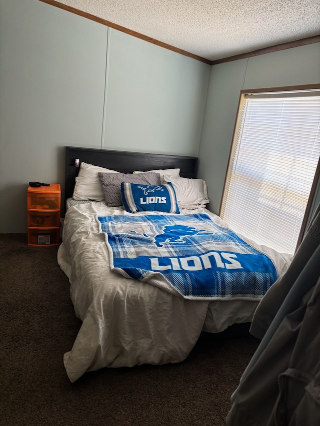 bedroom with carpet flooring, a textured ceiling, and crown molding