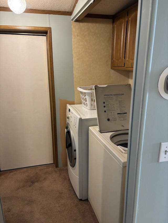 laundry area featuring cabinet space, washing machine and dryer, light colored carpet, and a textured ceiling