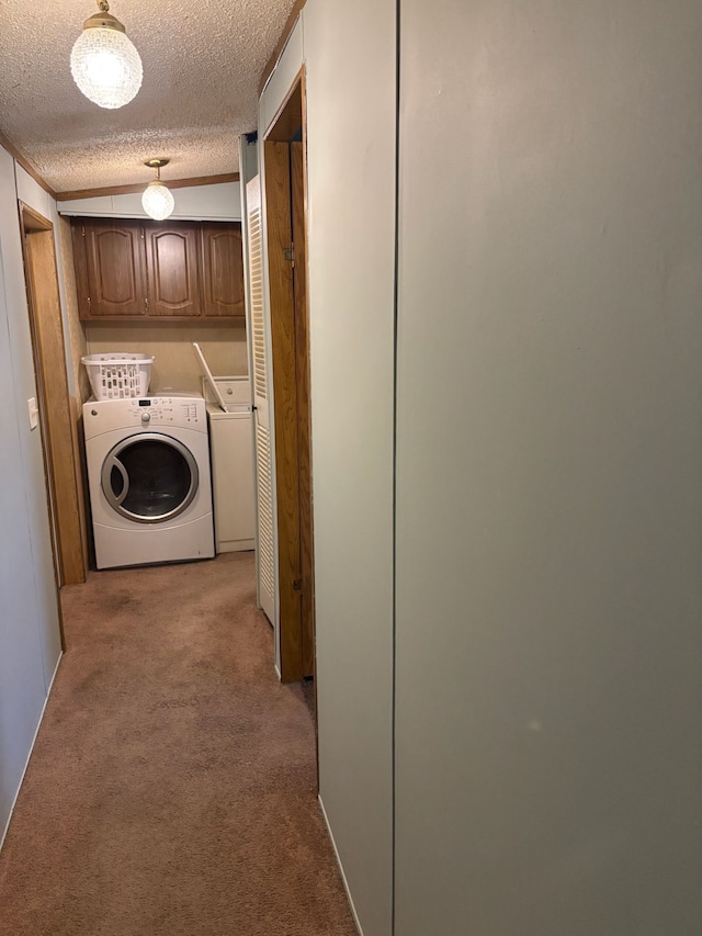 laundry area featuring light carpet, a textured ceiling, and washing machine and clothes dryer