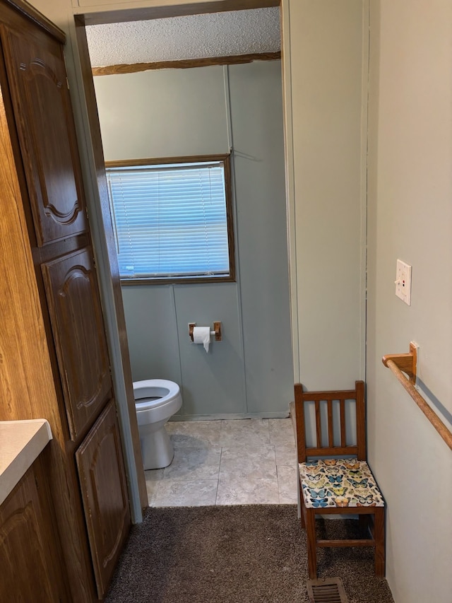 bathroom featuring tile patterned flooring, visible vents, and toilet