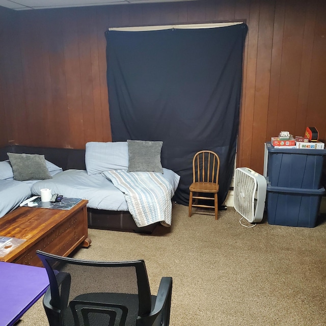 carpeted bedroom featuring wood walls