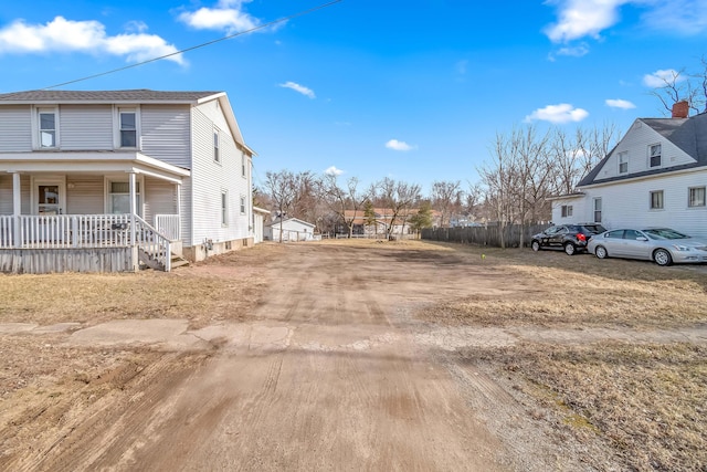 exterior space with covered porch and dirt driveway