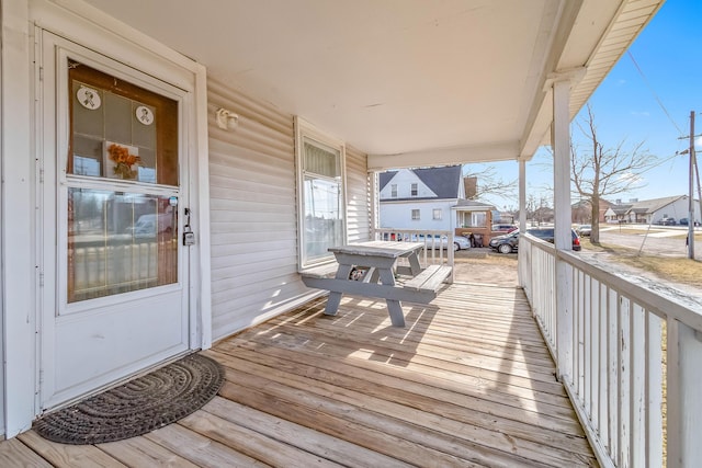 wooden terrace with a residential view and covered porch