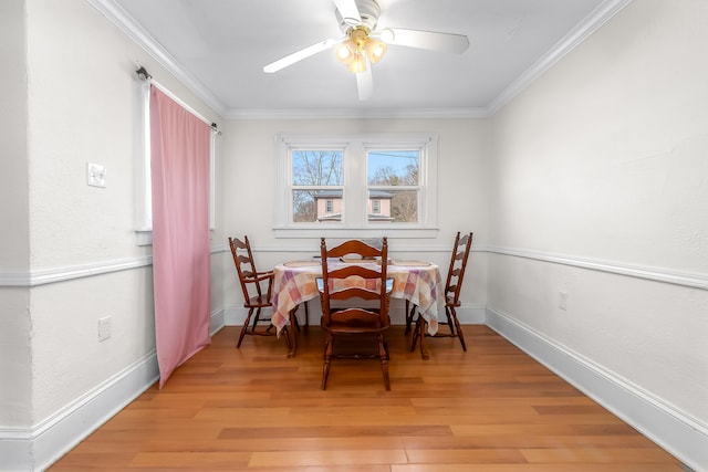 dining space with baseboards, light wood-style floors, ceiling fan, and crown molding