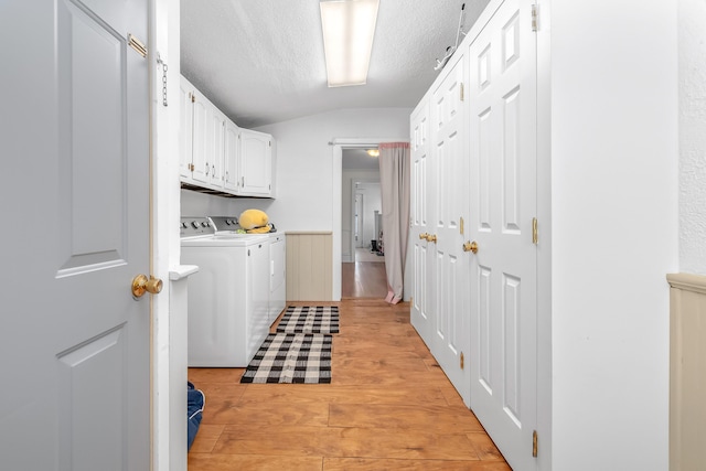 clothes washing area with cabinet space, a textured ceiling, independent washer and dryer, and light wood finished floors