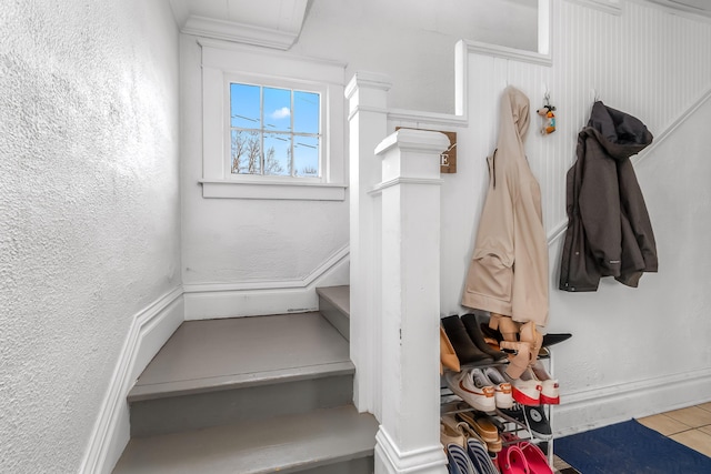 interior space with crown molding and a textured wall