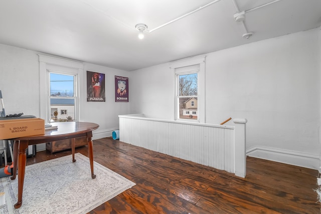 office space with baseboards, plenty of natural light, and wood finished floors