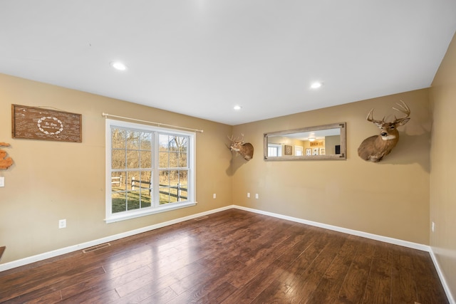 empty room with recessed lighting, baseboards, and wood-type flooring