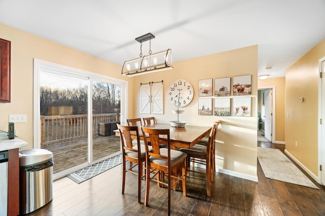 dining space featuring baseboards and dark wood finished floors